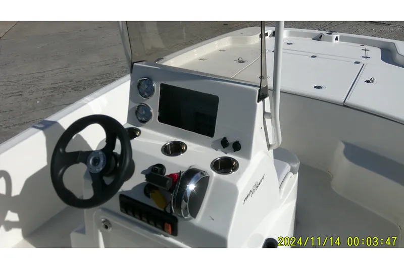 Slide: The Image of 2024 Mako Pro Skiff 19 CC boat console with steering wheel and gauges. - 27