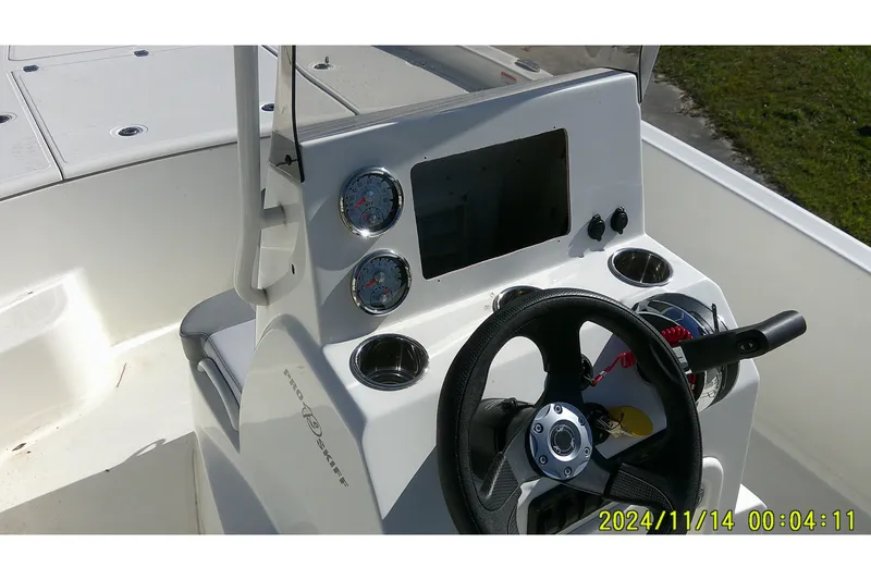 Slide: The Image of 2024 Mako Pro Skiff 19 CC boat console with steering wheel and gauges. - 30