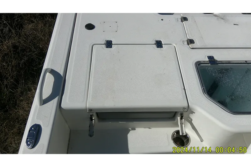 Slide: The Image of 2024 Mako Pro Skiff 19 CC boat deck with storage compartments and handle. - 33