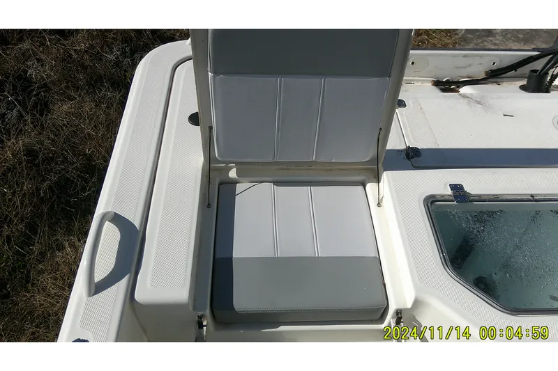 Slide: The Image of 2024 Mako Pro Skiff 19 CC boat seat and storage compartment detail. - 34