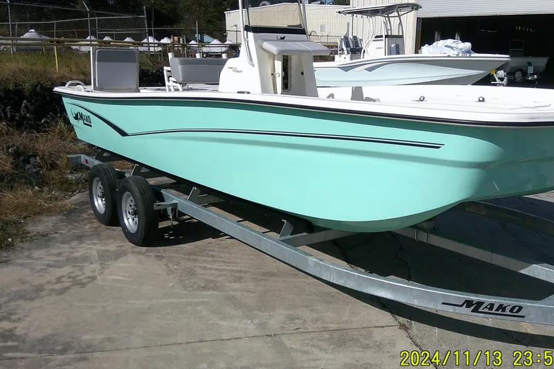 Slide: The Image of 2024 Mako Pro Skiff 19 CC boat on trailer, light blue hull, outdoor setting. - 4
