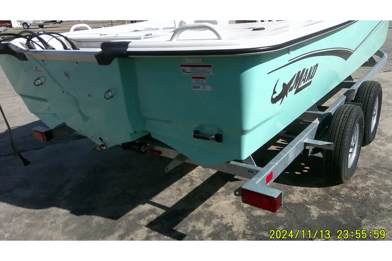 Slide: The Image of 2024 Mako Pro Skiff 19 CC boat on trailer, rear view, light blue color. - 6