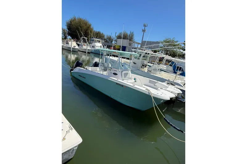 The Image of 2024 TwinVee 240 CFX CC boat docked in a marina under clear blue skies. - 1
