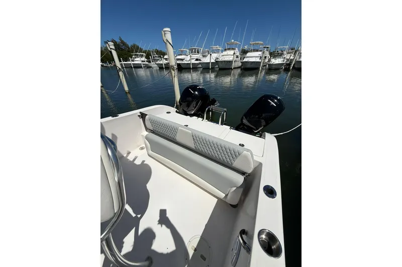 Slide: The Image of 2024 TwinVee 240 CFX CC boat with dual engines docked at marina. - 3