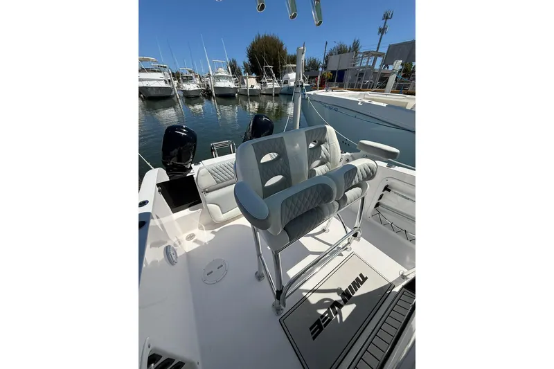 Slide: The Image of 2024 TwinVee 240 CFX CC boat interior with seating, docked at marina. - 6
