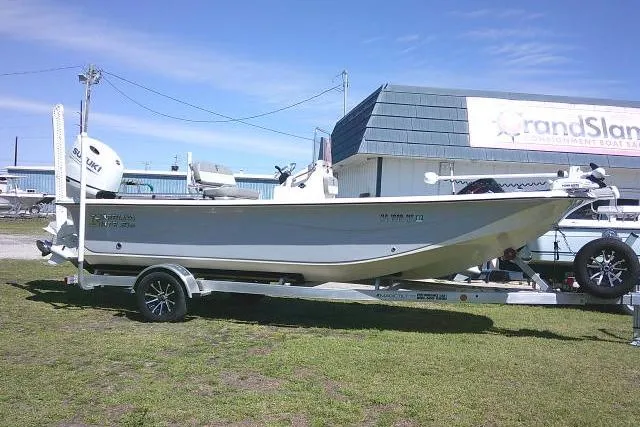 The Image of 2024 Carolina Skiff 21 LS boat on trailer, parked outdoors under clear sky. - 1