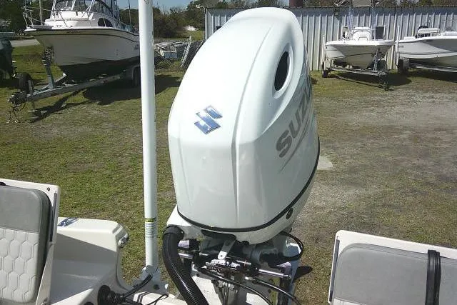Slide: The Image of 2024 Carolina Skiff 21 LS boat with Suzuki outboard motor in a marina setting. - 30
