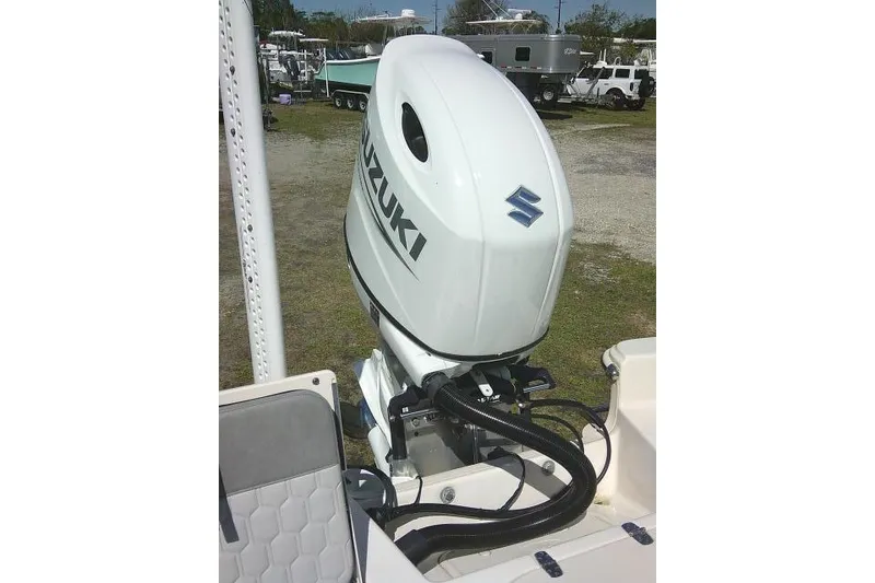 Slide: The Image of 2024 Carolina Skiff 21 LS with Suzuki outboard motor in a boatyard setting. - 35