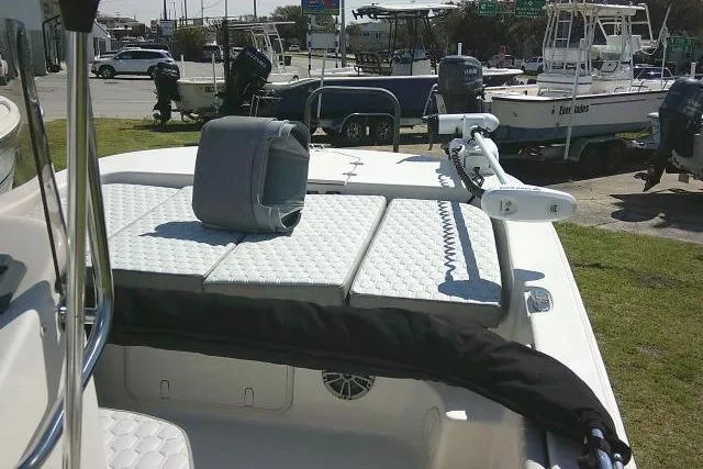 Slide: The Image of 2024 Carolina Skiff 21 LS boat with cushioned seating and trolling motor, parked outdoors. - 37