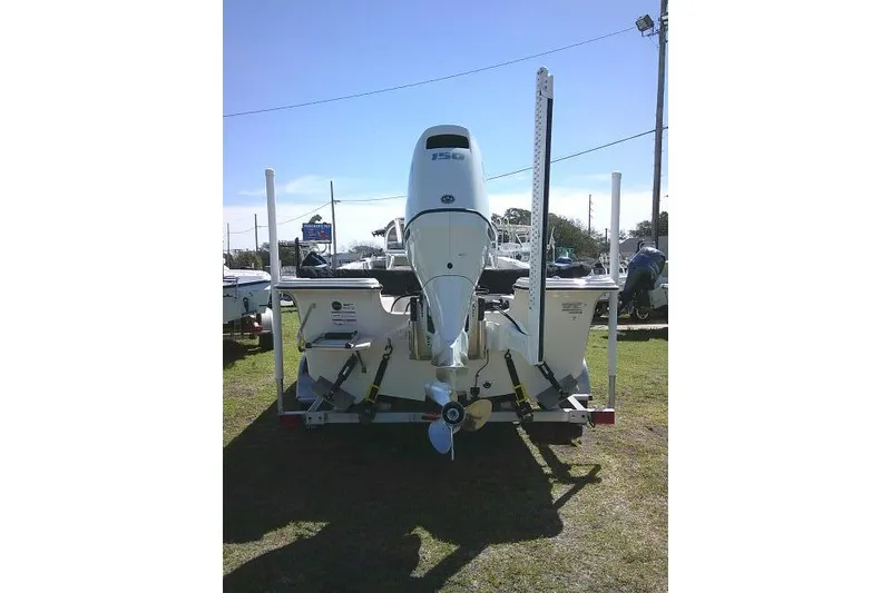 Slide: The Image of 2024 Carolina Skiff 21 LS boat with outboard motor, rear view on grass. - 9