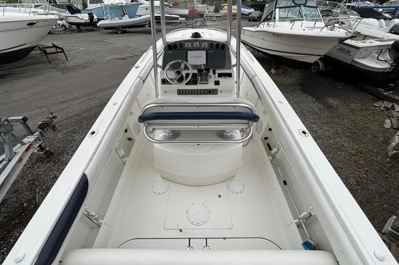 Slide: The Image of 1999 Wellcraft 302 Scarab Sport boat interior, featuring helm and seating, docked among other boats. - 2