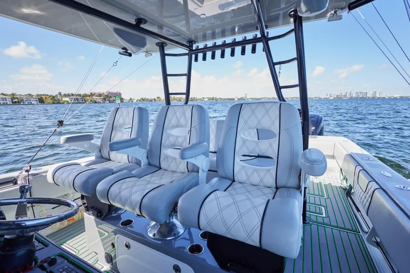 Slide: The Image of Luxury seating on 2022 Contender 44 ST boat, featuring plush white upholstery and ocean backdrop. - 20