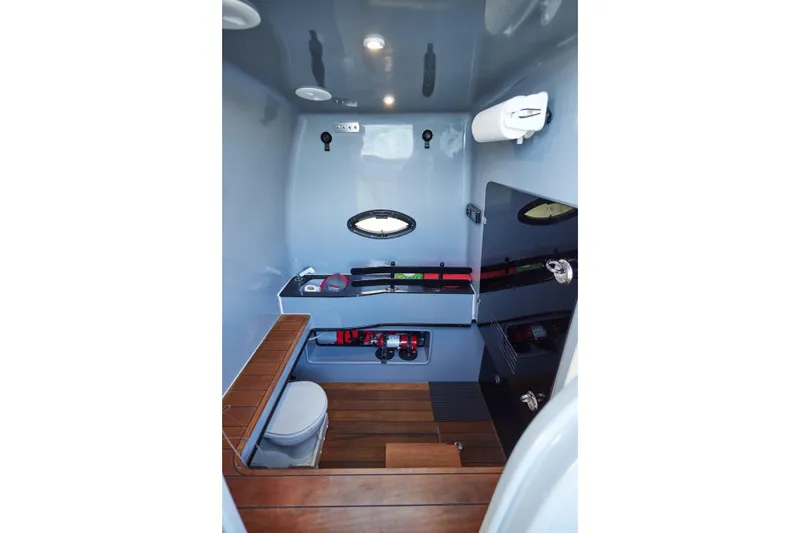 Slide: The Image of Interior of 2022 Contender 44 ST boat featuring a compact bathroom with wooden flooring. - 22