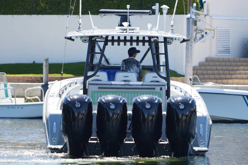 Slide: The Image of 2022 Contender 44 ST boat cruising on a sunny day near a dock. - 6