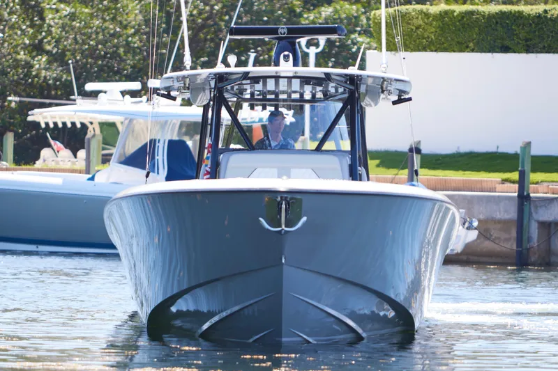 Slide: The Image of 2022 Contender 44 ST boat cruising in a marina, sleek design, calm waters. - 8