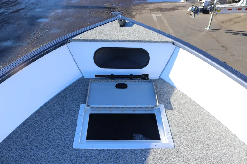 Slide: The Image of 2026 Smoker Craft Pro Lodge 160 boat interior with storage compartment open. - 10