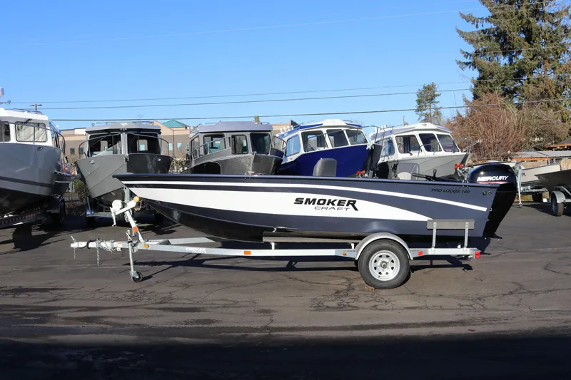 Slide: The Image of 2026 Smoker Craft Pro Lodge 160 boat on trailer, parked outdoors. - 21
