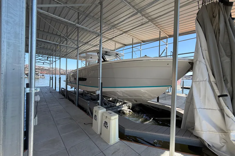 Slide: The Image of 2023 Regal 38 SAV boat docked under a covered marina with Yamaha engines. - 18