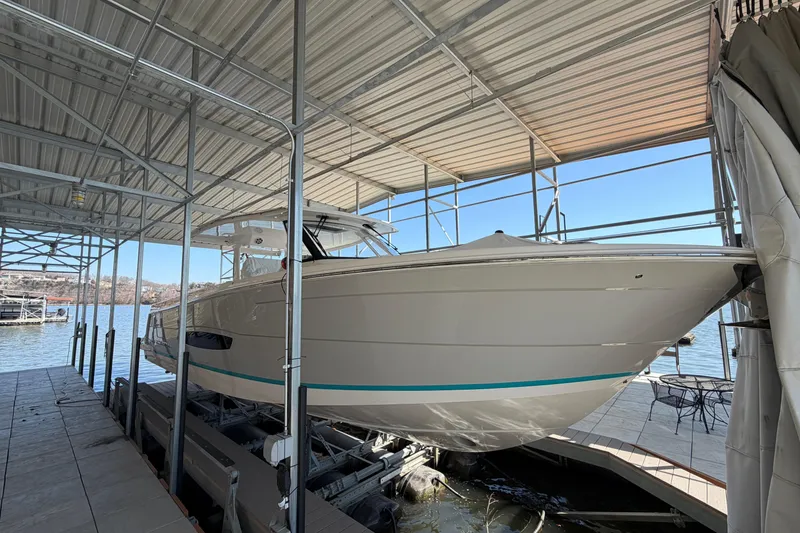 Slide: The Image of 2023 Regal 38 SAV boat with triple Yamaha outboard engines docked by the water. - 19