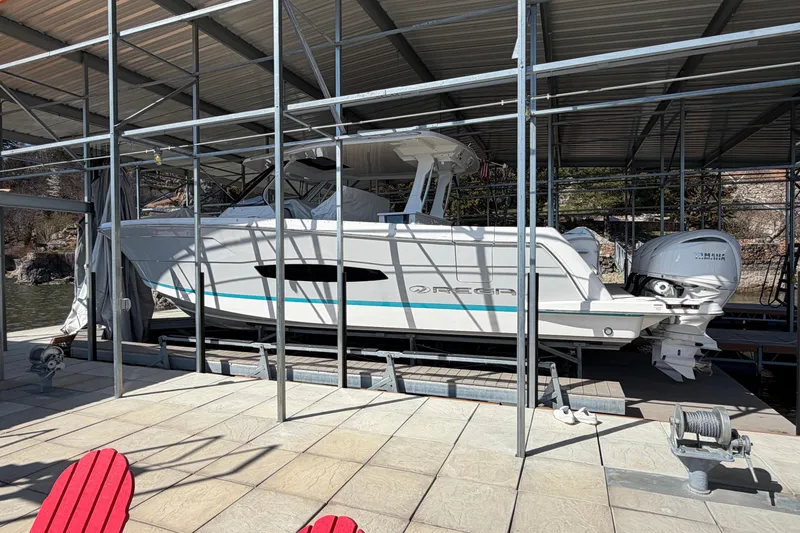 Slide: The Image of 2023 Regal 38 SAV boat with triple outboard engines docked by the water. - 20
