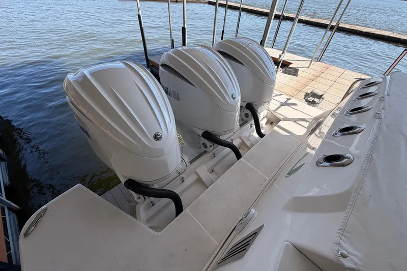 Slide: The Image of 2023 Regal 38 SAV boat with triple Yamaha outboard engines docked. - 21