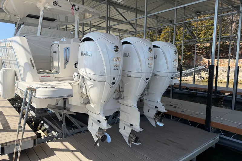 Slide: The Image of 2023 Regal 38 SAV boat docked under a metal canopy by the water. - 23