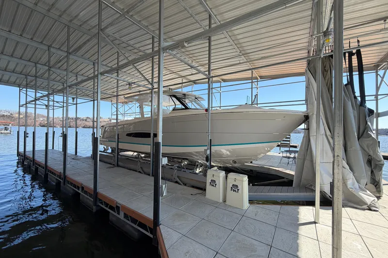 Slide: The Image of 2023 Regal 38 SAV boat interior with seating and wooden table, docked by the water. - 27