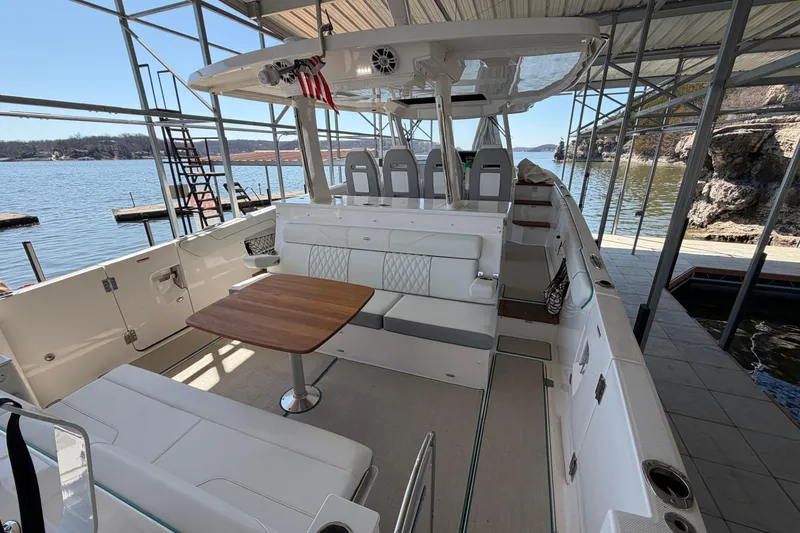Slide: The Image of Luxurious seating area on 2023 Regal 38 SAV boat with wooden table and waterfront view. - 28