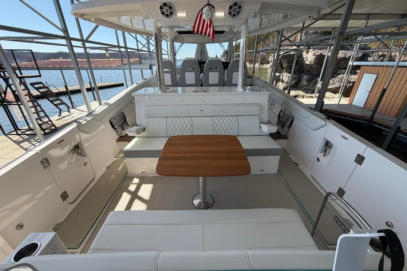 Slide: The Image of Luxurious seating area on 2023 Regal 38 SAV boat with wooden table and water view. - 29