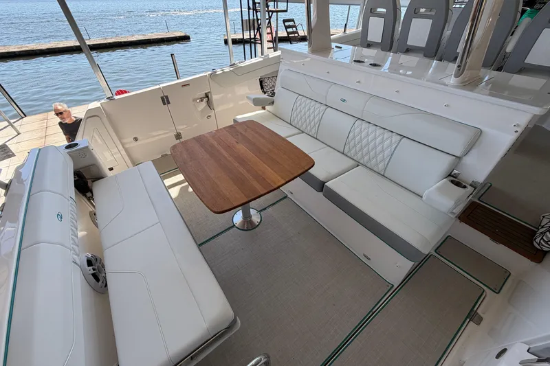 Slide: The Image of Luxurious seating area on 2023 Regal 38 SAV boat with wooden table and white upholstery. - 30