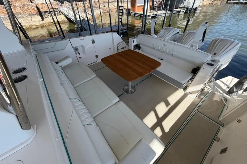 Slide: The Image of 2023 Regal 38 SAV boat interior with seating and helm, docked by the water. - 31