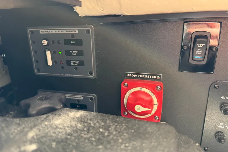 Slide: The Image of 2023 Regal 38 SAV boat interior with protective covers, docked by a scenic shoreline. - 58