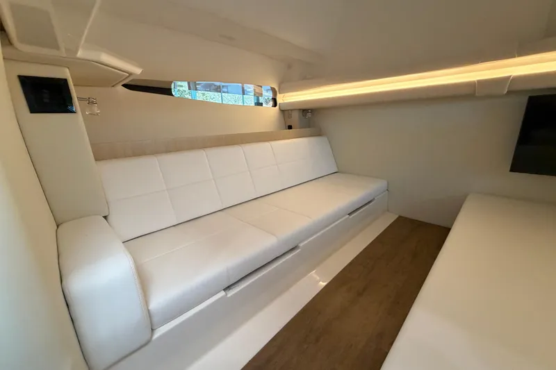 Slide: The Image of 2023 Regal 38 SAV interior with white seating, wood flooring, and wall-mounted TV. - 64