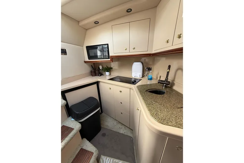 Slide: The Image of 2001 Cruisers Yachts 3470 Express kitchen with microwave, sink, and storage cabinets. - 10