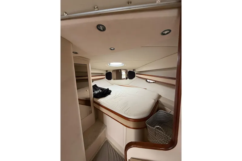 Slide: The Image of 2001 Cruisers Yachts 3470 Express cabin interior with bed and storage. - 12