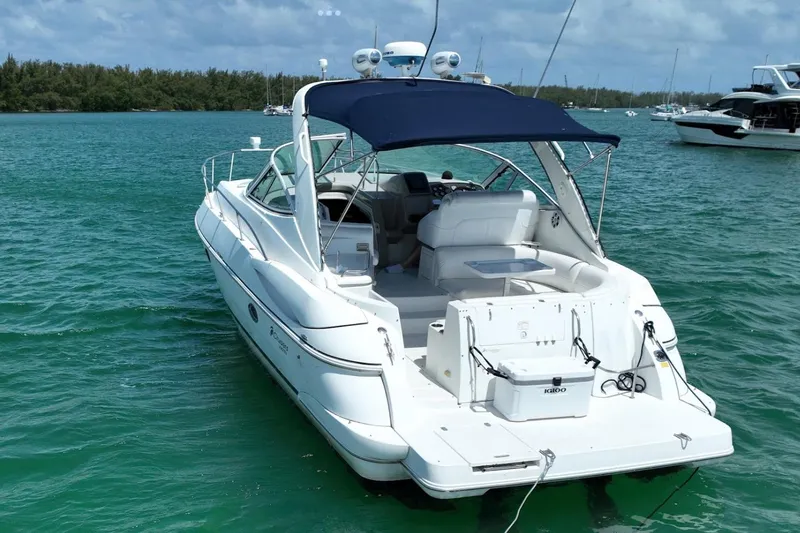 Slide: The Image of 2001 Cruisers Yachts 3470 Express on turquoise water, featuring a sleek design and spacious deck. - 13