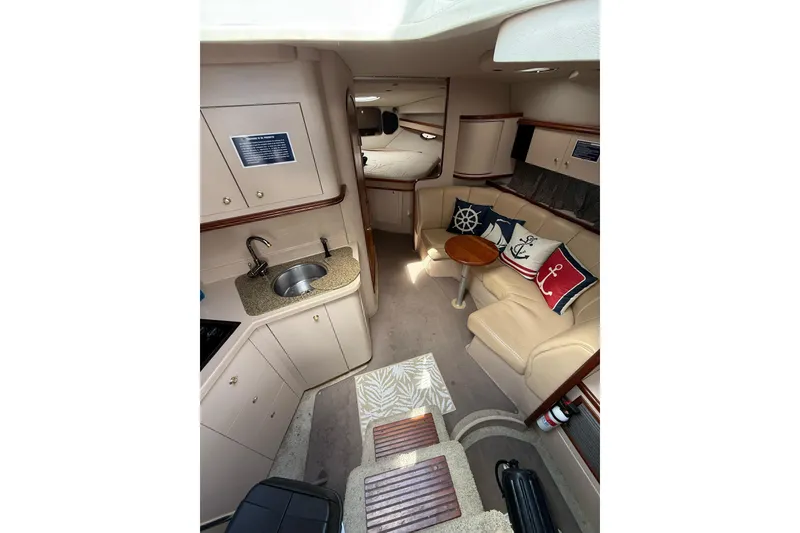 Slide: The Image of 2001 Cruisers Yachts 3470 Express interior with kitchenette, seating area, and nautical decor. - 6