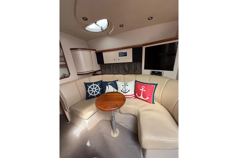Slide: The Image of Interior of 2001 Cruisers Yachts 3470 Express with nautical-themed cushions and cozy seating area. - 7
