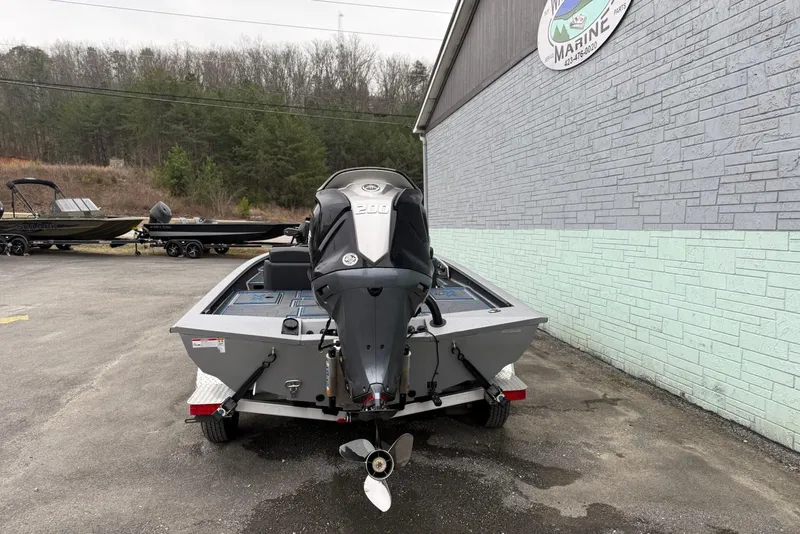 Slide: The Image of 2026 Xpress X19 Pro boat with powerful outboard motor, parked outside marine shop. - 9