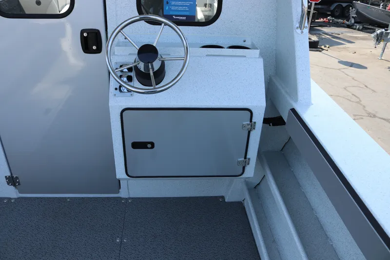 Slide: The Image of Interior of 2026 KingFisher 2425 Escape HT boat, featuring steering wheel and storage compartment. - 11
