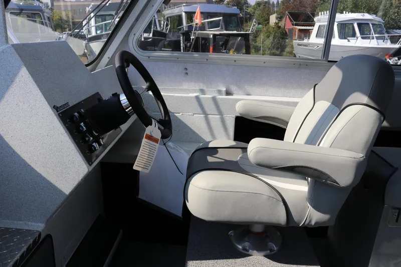Slide: The Image of Interior of 2026 KingFisher 2425 Escape HT boat, featuring steering wheel and captain's chair. - 22