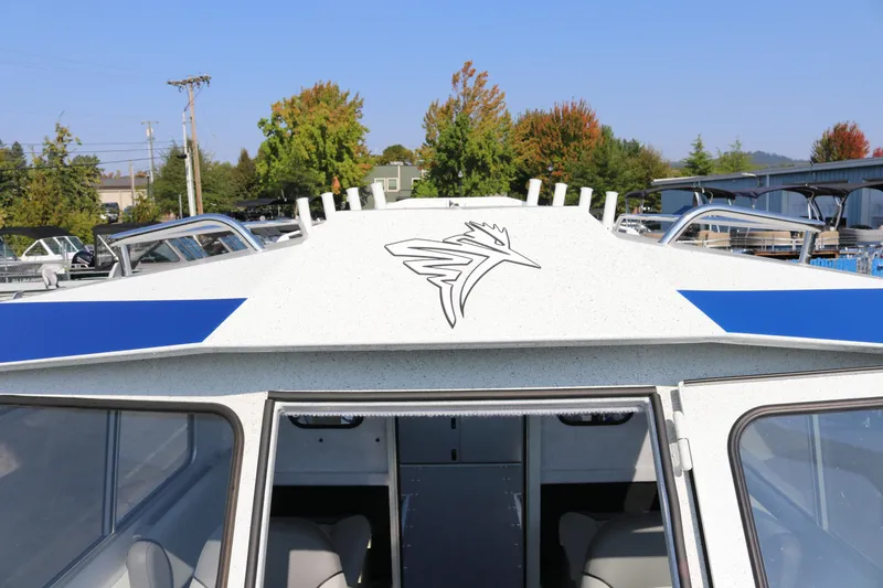 Slide: The Image of 2026 KingFisher 2425 Escape HT boat with logo, parked outdoors under clear sky. - 26