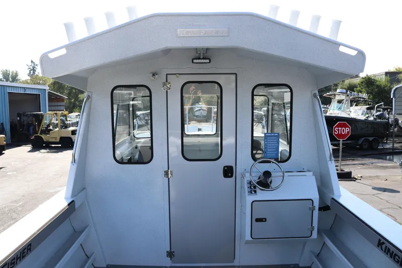 Slide: The Image of 2026 KingFisher 2425 Escape HT boat, rear view with helm and cabin door. - 5