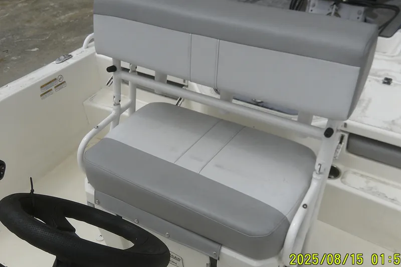 Slide: The Image of 2023 Mako Pro Skiff 19 CC boat interior with gray seating and steering wheel. - 15