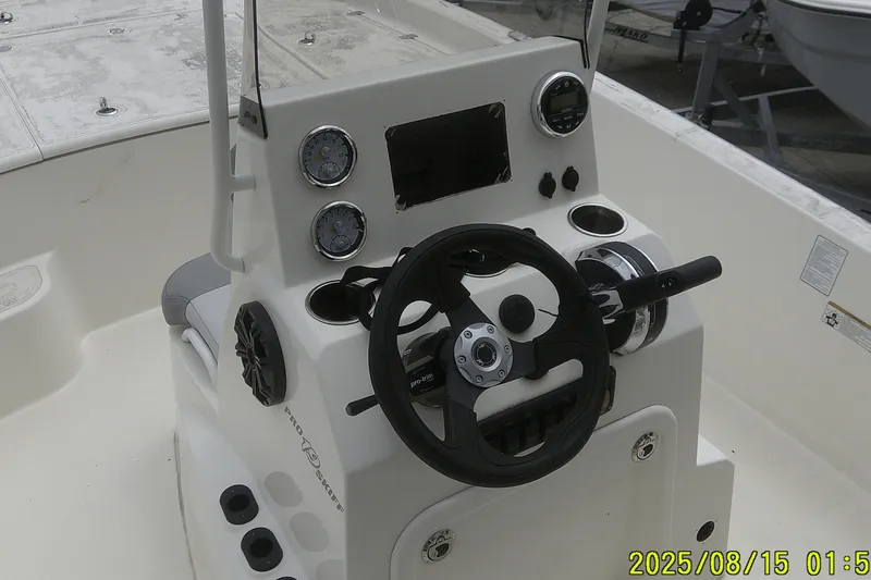 Slide: The Image of 2023 Mako Pro Skiff 19 CC boat console with steering wheel and gauges. - 16