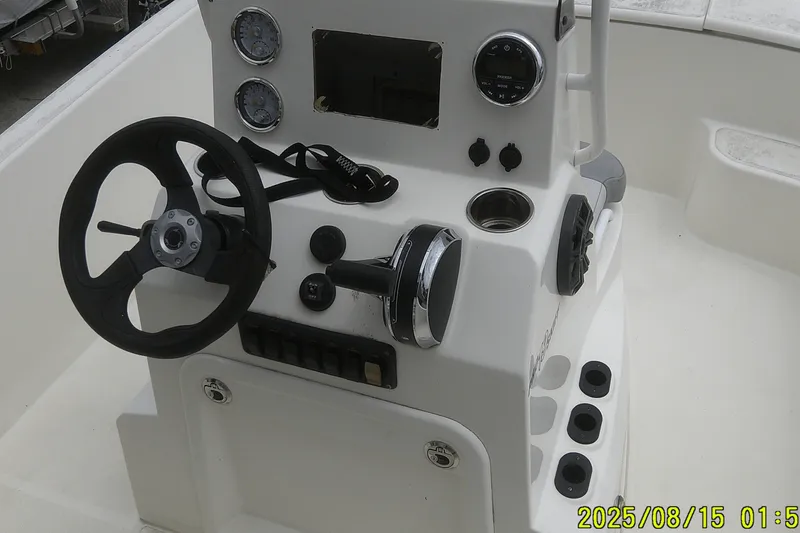 Slide: The Image of 2023 Mako Pro Skiff 19 CC boat console with steering wheel and gauges. - 17