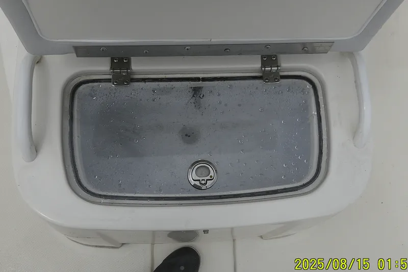 Slide: The Image of Livewell on 2023 Mako Pro Skiff 19 CC boat, top view with water droplets. - 19