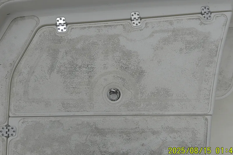 Slide: The Image of 2023 Mako Pro Skiff 19 CC boat deck with metal hinges and latch. - 28