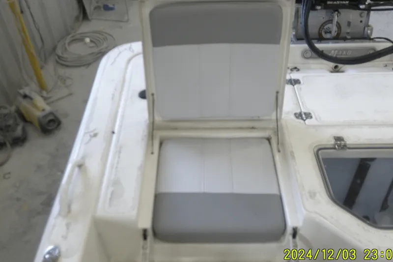 Slide: The Image of 2023 Mako Pro Skiff 19 CC boat seat with storage compartment open. - 48