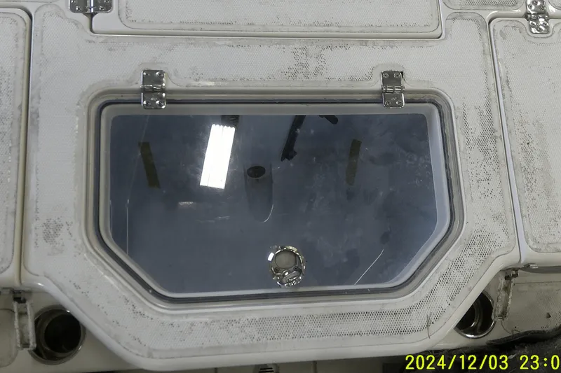 Slide: The Image of 2023 Mako Pro Skiff 19 CC boat hatch with metal hinges and textured surface. - 49